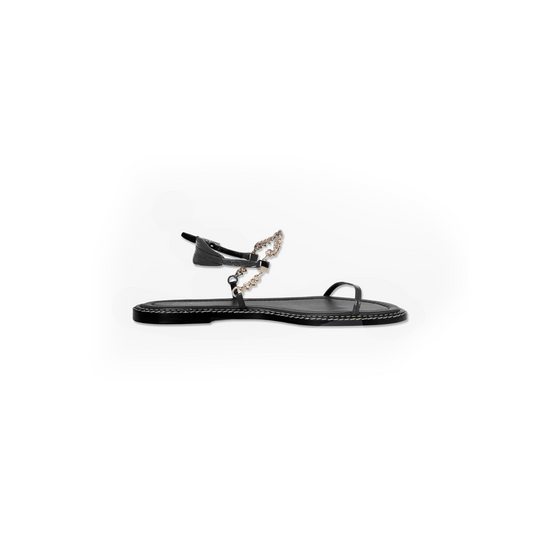 Black flat sandal with chain detail on a white background