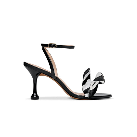Black high-heeled sandal with a zebra-patterned bow on a white background